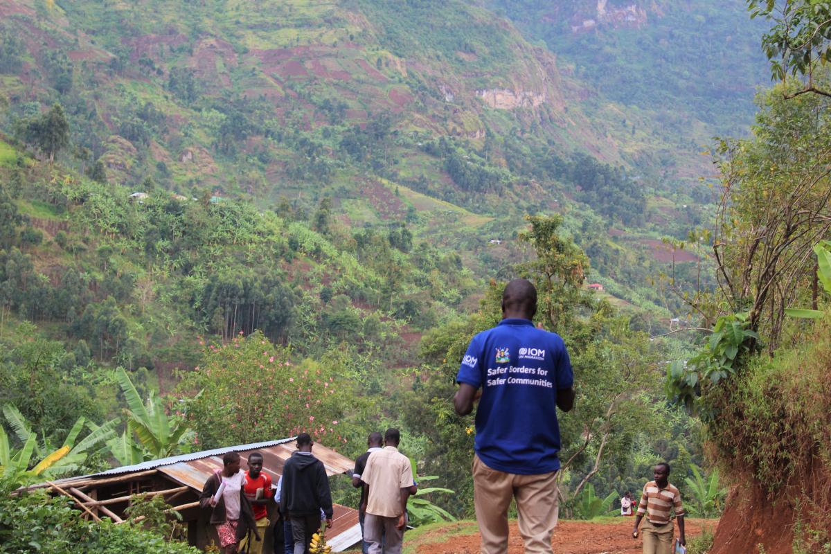 Data enumerators going down the steep slopes of Bududa in March 2021. The enumerators had to walk for about 10 kilometers to reach Nametsi due to the terrain and impassable roads. Photo: IOM/Abubaker Mayemba