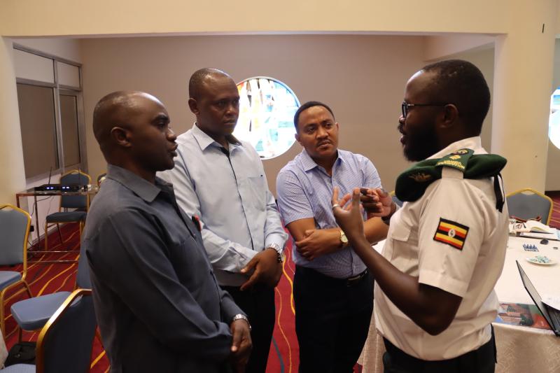 Uganda Snr Immigration Officer Joseph H Wejuli speaks with colleagues from Tanzania at the launch in Nairobi.